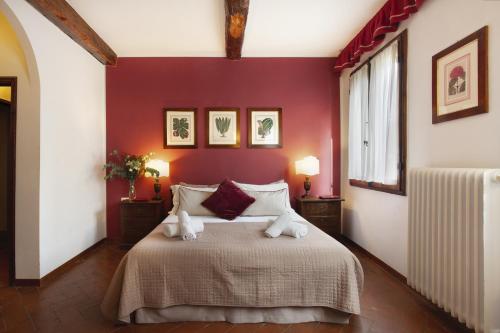 Un dormitorio con una cama grande con paredes rojas. en S. Spirito Studio Flat, en Florencia