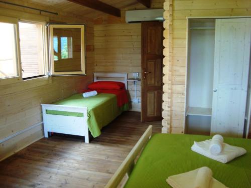 a room with two beds in a wooden cabin at B&B Lao in Papasidero