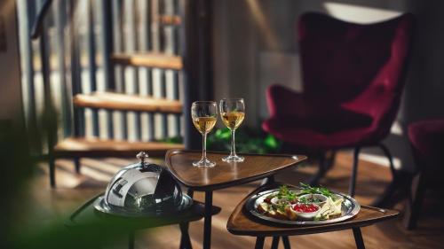 Kass Diamond Resort في Tsalka: طاولتين مع كؤوس من النبيذ وصحن من الطعام