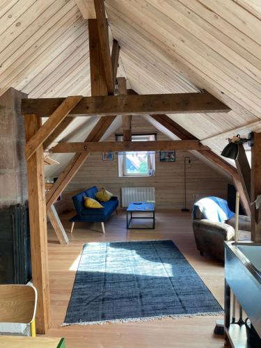 a living room with wooden ceilings and a blue couch at Mon refuge en Vasgovie in Meisenthal