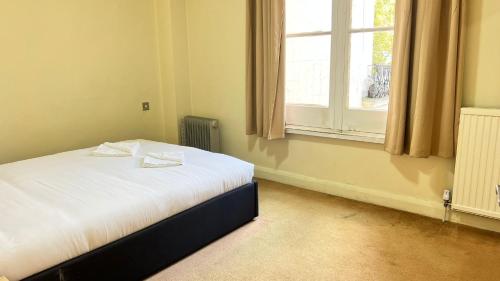 una piccola camera con letto e finestra di Budget 2 Bedroom Apartment in Paddington a Londra