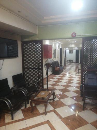 uma sala de estar com cadeiras pretas e um piso em xadrez em Hotel Room with Breakfast -Beni sweif em Beni Suef