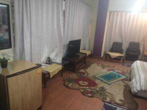 a living room with a television and a living room with at Hotel Room with Breakfast -Beni sweif in Beni Suef