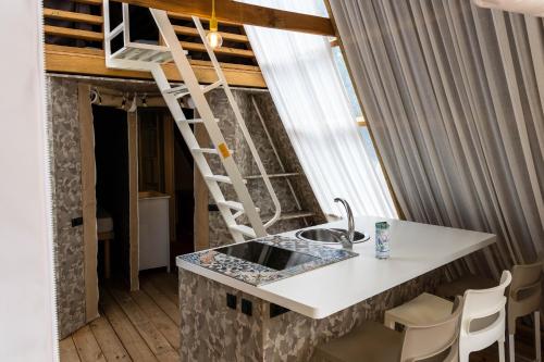 Casa Dei Prati Camping Village في لاكونا: مطبخ مع مغسلة و سلم في الغرفة