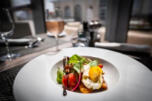 a white plate with a salad on a table at Côté Thalasso Hôtel & Spa Marin in Banyuls-sur-Mer
