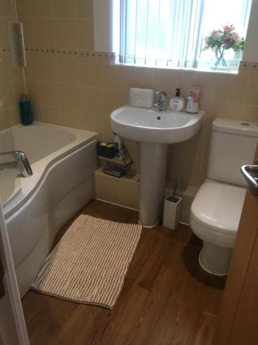 ein Badezimmer mit einer Badewanne, einem Waschbecken und einem WC in der Unterkunft Villa Belle Three bedroom Basildon in Basildon