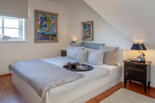Un dormitorio con una cama blanca con una bandeja de comida. en Haus Traumzeit en Braderup