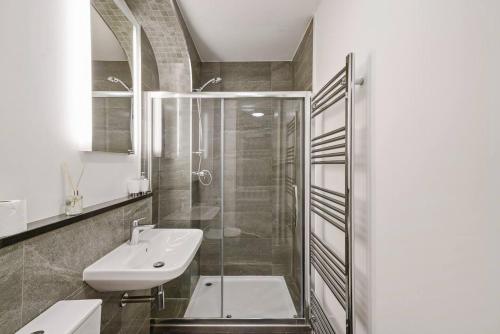 y baño con ducha acristalada y lavamanos. en Stunning Central Wakefield Apartment 2 - Parking, en Wakefield