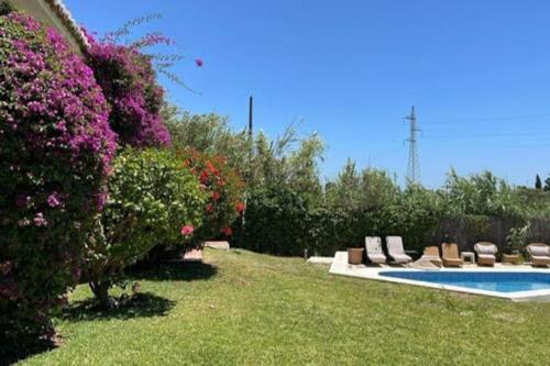 une cour avec une piscine et des fleurs violettes dans l'établissement Marbella large rustic family villa to rent, à Estepona