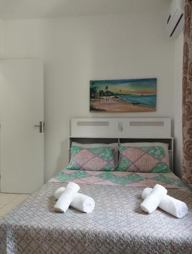 ein Schlafzimmer mit einem Bett mit zwei Handtüchern darauf in der Unterkunft Sweet Room Coroa Vermelha in Santa Cruz Cabrália