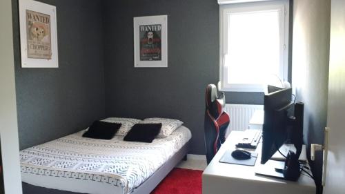 une chambre avec un lit et un bureau avec un ordinateur dans l'établissement Au jardin de la seiche, à Noyal-Châtillon-sur-Seich