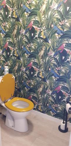 La salle de bains est pourvue de toilettes et de papier peint tropical. dans l'établissement Au jardin de la seiche, à Noyal-Châtillon-sur-Seich