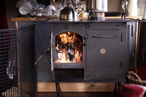 una estufa con fuego en su interior en Seven Hills Hideaway - Blorenge, en Llanvetherine