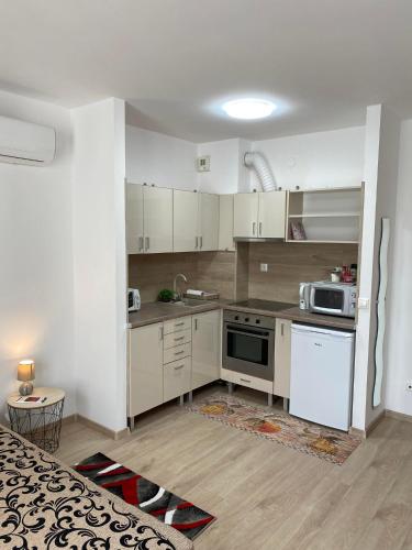a kitchen with white cabinets and a stove top oven at Danka Szálláshely in Debrecen