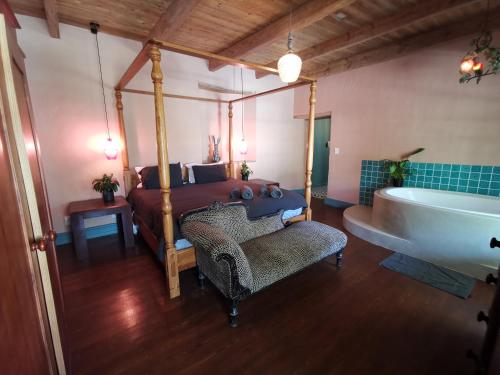 a bedroom with a bed and a bath tub and a bed and a sink at Greyton Toad Hall Guesthouse - no load shedding in Greyton