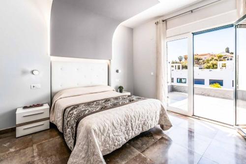 1 dormitorio con cama y ventana grande en Villa Irisa en Nerja