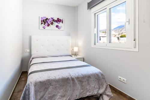 Habitación blanca con cama y ventana en Villa Irisa en Nerja