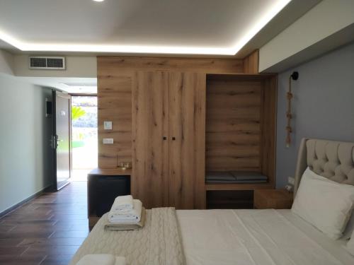 a bedroom with a large bed and a wooden closet at Anthidon Nature Estate & Farm in Chalkida