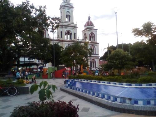 a large white building with a clock tower at Hotel Central Park in El Espinal