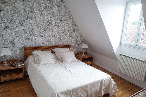 a bedroom with a bed with white sheets and a wallpaper at Gîte du Val d'Anglin au calme à 7 km de Le Blanc in Mauvières