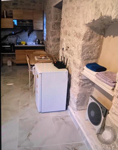 a kitchen with a white refrigerator and a stone wall at Stone tower east mani 4 in Agriliá