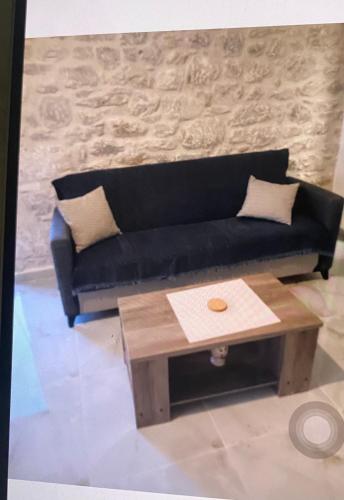 a living room with a black couch and a coffee table at Stone tower east mani 4 in Agriliá