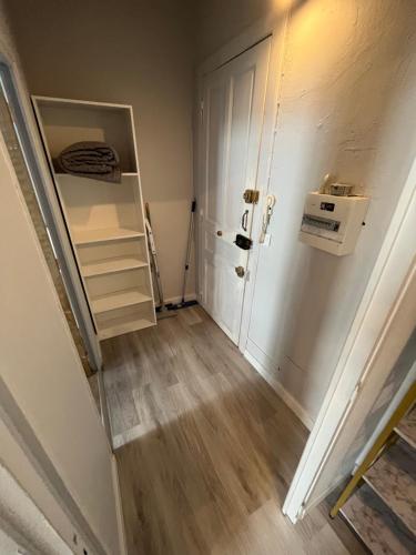 un couloir vide avec une porte et un réfrigérateur dans l'établissement Appartement Chaleureux 2 pièces, à Sète