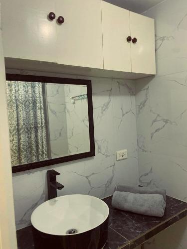 W łazience znajduje się umywalka i lustro. w obiekcie WIND RESIDENCES SMDC TOWER 2 w mieście Tagaytay