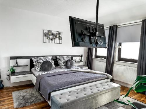 a bedroom with a bed and a flat screen tv at Ebony & Ivory Ferienwohnung in Steinhude