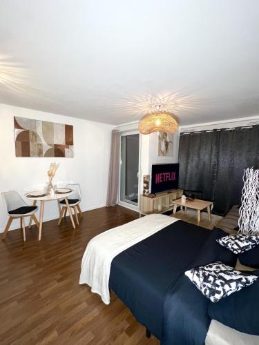 1 dormitorio con 1 cama, 1 mesa y 1 silla en "MoonLighT" Gare à 10min de PARIS, WIFI, TERRASSE , PARKING, en Argenteuil