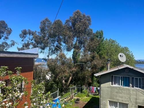 a view of a house and a tree at Hostal Mirador Quellón in Quellón