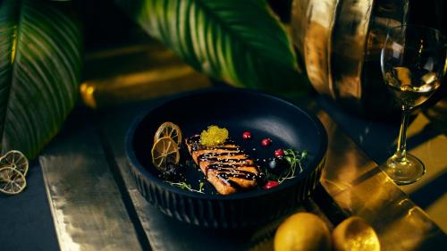 a blue bowl of food on a table with a wine glass at Kass Diamond Resort in Tsalka