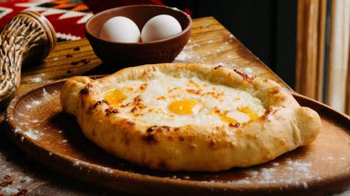 an egg pizza on a plate on a table at Kass Diamond Resort in Tsalka
