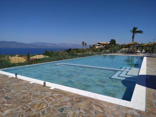 a large swimming pool with a view of the water at Anthidon Nature Estate & Farm in Chalkida