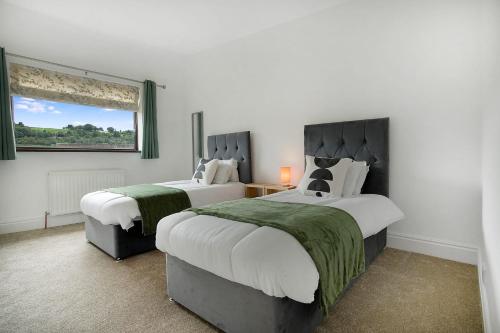 1 dormitorio con 2 camas con sábanas verdes y blancas en Lovely 2-Bedroom Home in Langley Park, Sleeps 4 en Durham