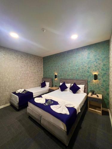 a hotel room with two beds and two tables at GÜNEŞLİ AİRPORT SUİTE HOTEL in Istanbul