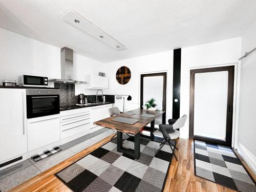 eine Küche mit einem Holztisch und weißen Schränken in der Unterkunft Ebony & Ivory Ferienwohnung in Steinhude