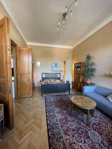 a living room with a bed and a blue couch at Apartmán v historickom centre Košíc in Košice