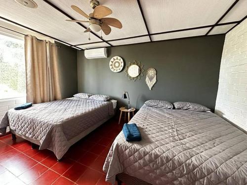 1 dormitorio con 2 camas y ventilador de techo en Outstanding House in San Benito! en San Salvador