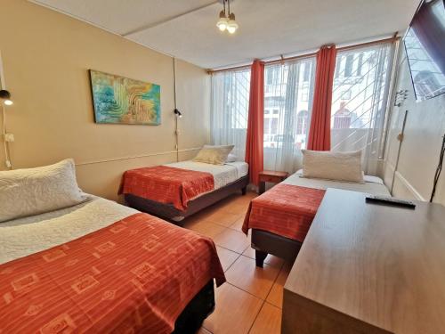 ein Hotelzimmer mit 2 Betten und einem Fenster in der Unterkunft Hotel Inti - Llanka in Iquique