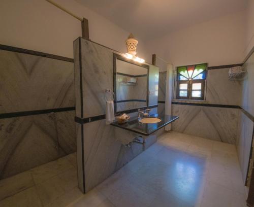 a bathroom with a sink and a mirror at Ranakpur Safari Resort in Sādri