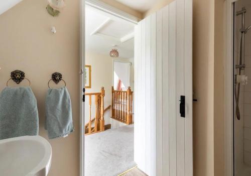 a bathroom with a white sink and a mirror at Locks Lane Cottage in Geldeston