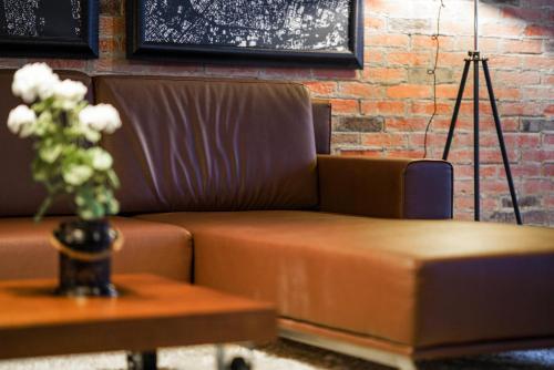 a brown couch and a table with a vase of flowers at VIP House Glavatarski Han in Glavatartsi