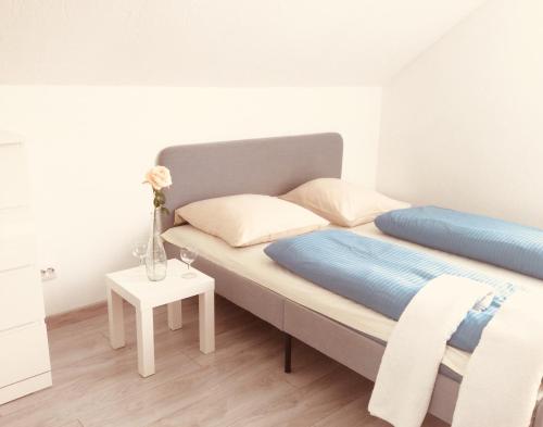 een slaapkamer met een bed met een vaas op een tafel bij Miko apartamentai in Kaunas