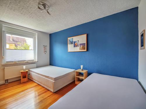 ein Schlafzimmer mit 2 Betten und einer blauen Wand in der Unterkunft FeWo beim Schlafhaus in Völklingen
