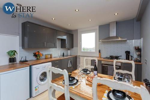 a kitchen with a table and a washer and dryer at Stylish 3 Bedroom Apartment, Edinburgh in Edinburgh
