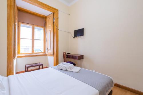 a bedroom with a bed with two towels on it at Norte Guest House in Lisbon