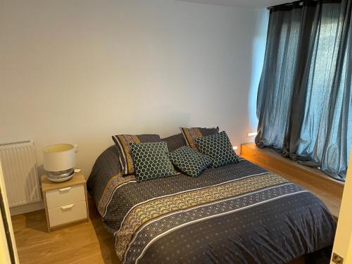 a bedroom with a bed with pillows on it at Suite parentale avec salle de bains et toilettes privées in Genas