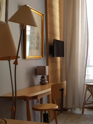 une pièce avec un bureau avec une lampe et un miroir dans l'établissement le petit chalet de Grenoble, à Grenoble