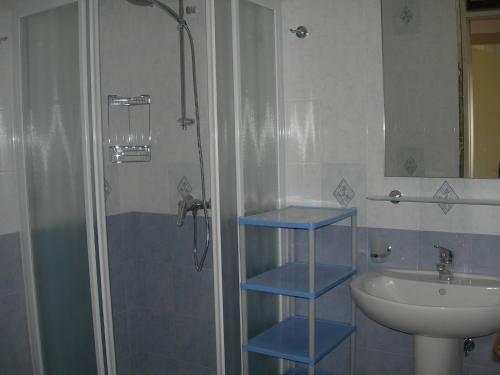 een badkamer met blauwe planken naast een wastafel en een douche bij Precious villa with private garden and barbecue in Porto Santa Margherita di Caorle